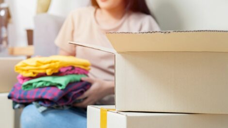 Young woman preparing seasonal clothes for self storage